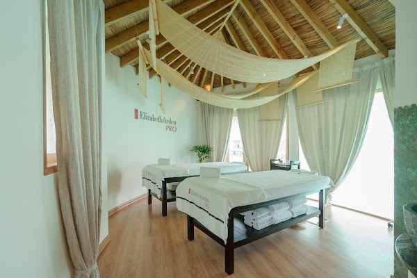 Spa treatment room with two massage beds beneath a thatched timber ceiling at You & Me Maldives, Raa