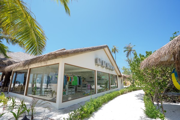 Thatched-roof boutique with large glass windows beside a white sand path at You & Me Maldives, Raa
