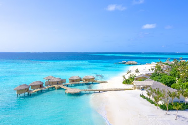 Aerial view of overwater villas and white sand beach at You & Me Maldives, Raa Atoll, with turquoise