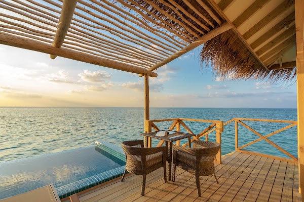 Thatched pergola over a wooden deck with wicker chairs, table and plunge pool overlooking the sea at You & Me